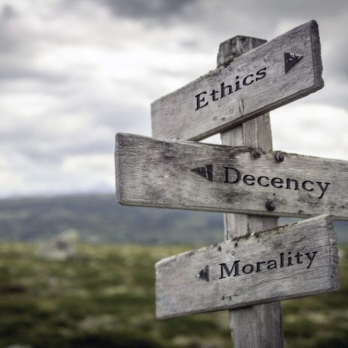 Ethics, decency and morality text on wooden sign post outdoors in landscape scenery. Business, quotes and motivational theme concept.